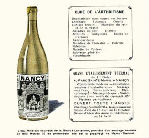 publicité sur laquelle on voit une bouteille en verre avec une étiquette grilles Jean Lamour de la place Stanislas